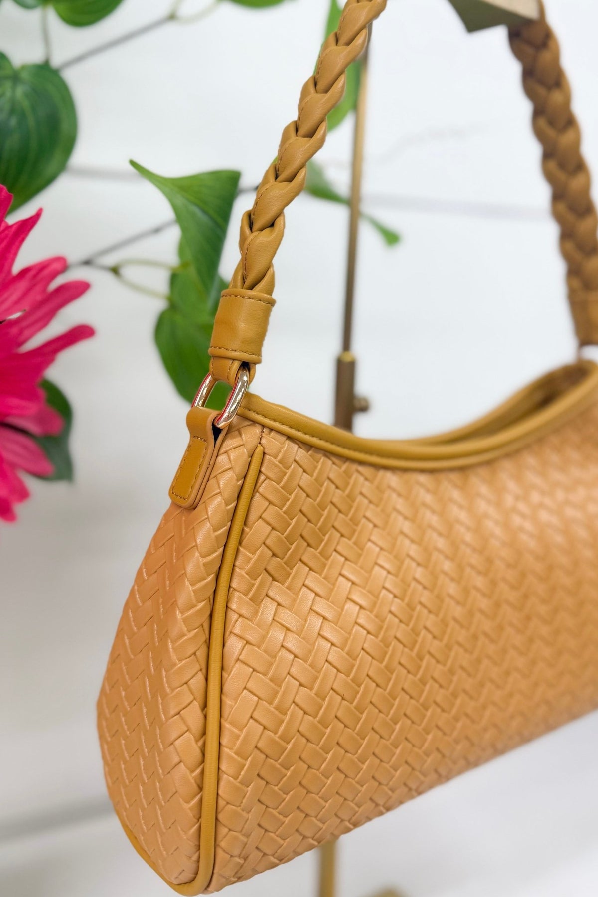 Tan woven handbag with a braided top handle