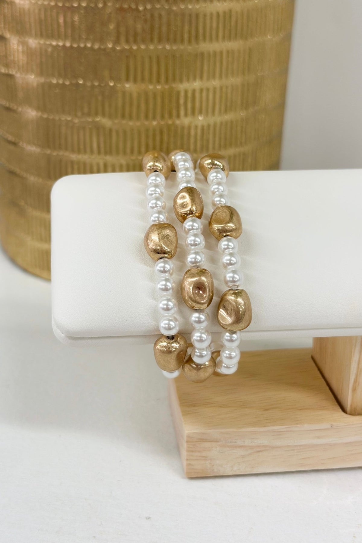 Worn gold and cream beaded bracelet in three rows