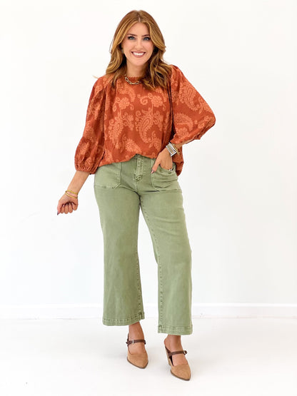 Terracotta lace pattern blouse with voluminous puff sleeves and curved hem