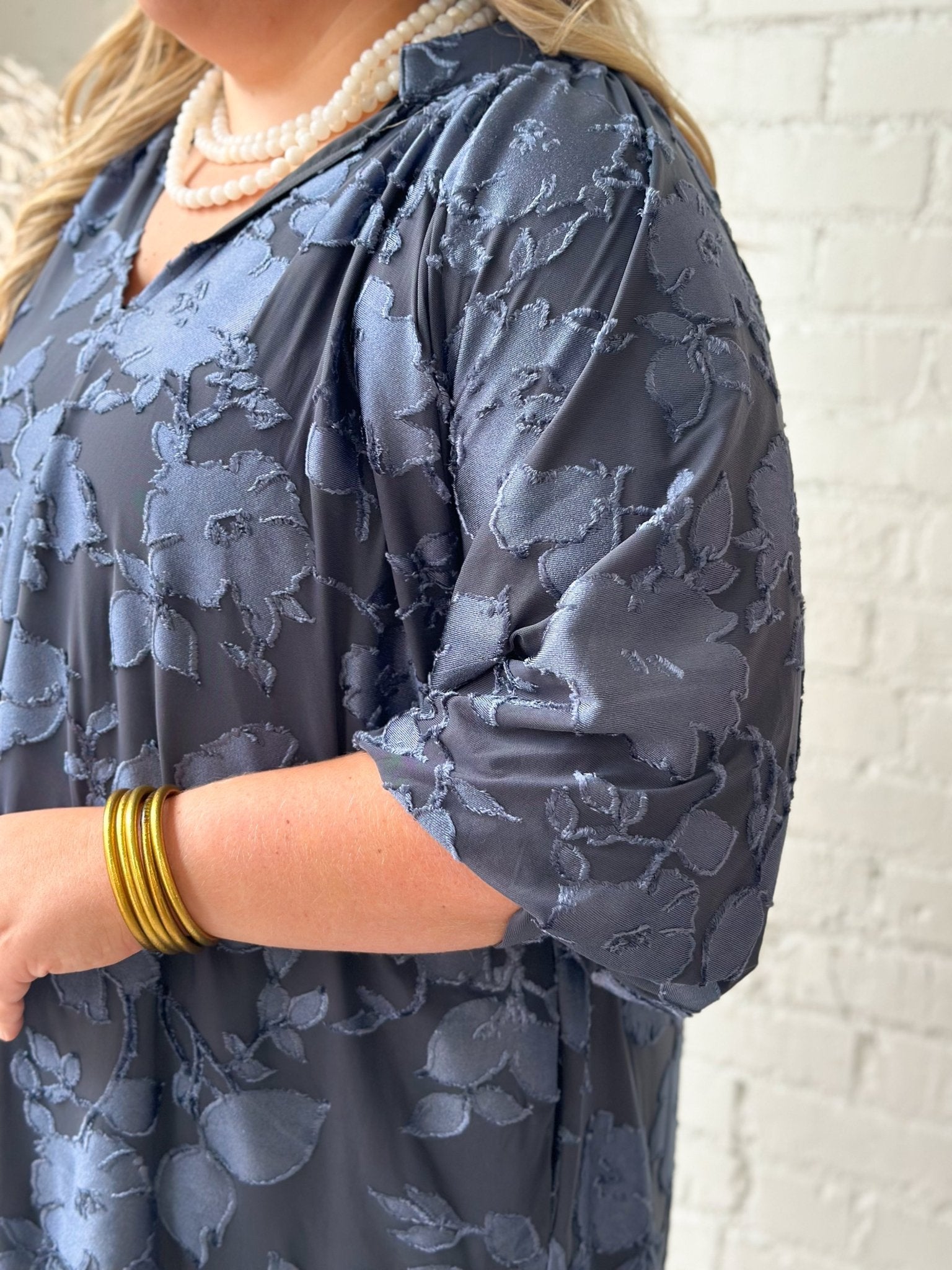 Scalloped neckline on a slate blue velvet dress