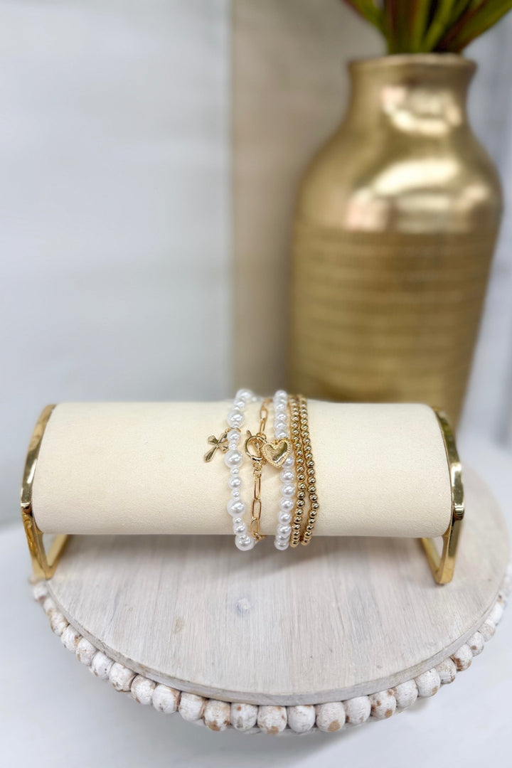 Five-row white pearl bracelet with a gold cross charm