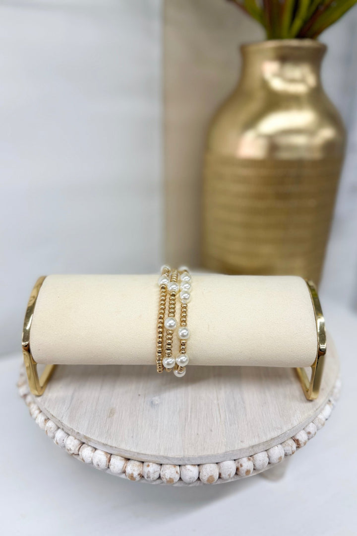 Worn gold three-row bracelet with cream pearl stations