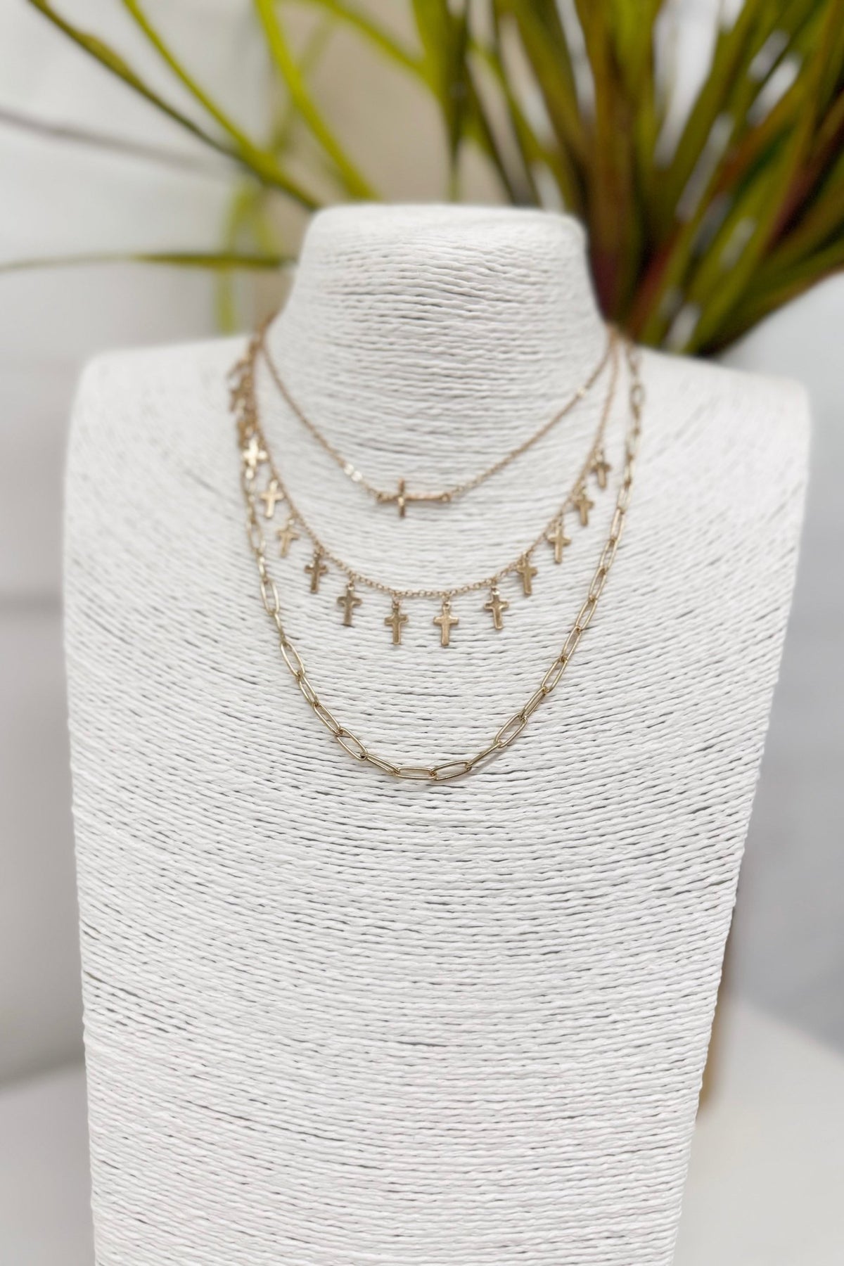 Worn gold necklace with multiple cross charms