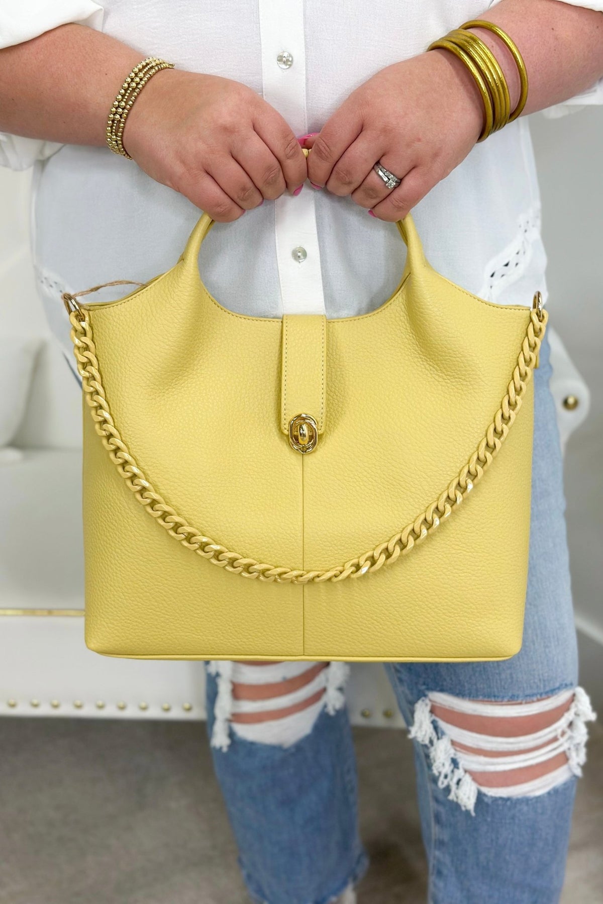 Yellow handbag with a chain-trimmed strap